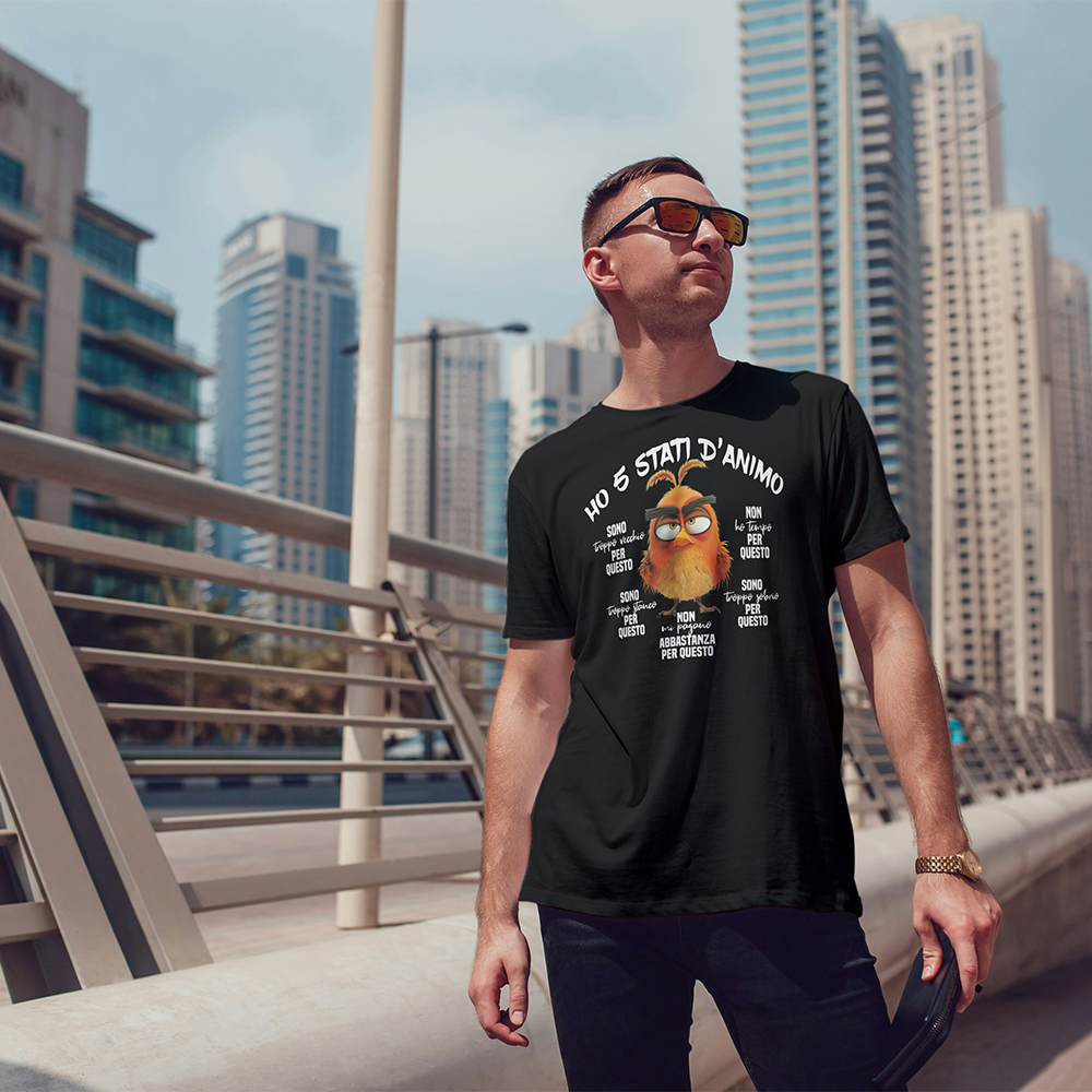 Due T-shirt 5 stati d'animo de Il mio negozio, in bianco e nero, presentano un gufo arancione a fumetti con un testo in italiano sui cinque stati d'animo. Entrambe le magliette personalizzate sono appese a grucce di legno in mezzo alle foglie: perfette come idee regalo!.