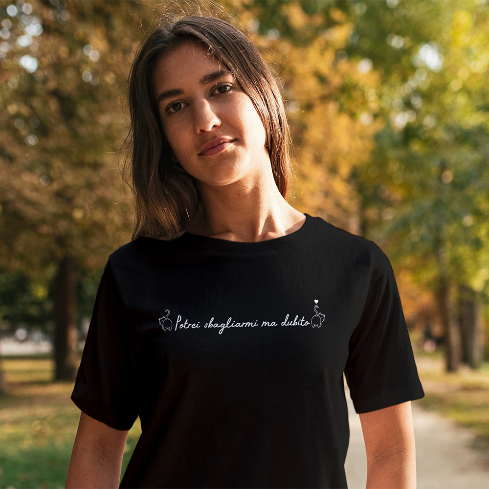 Due T-shirt Dubito Donna de Il mio negozio, una bianca e una nera con la scritta "Përur slogjanme me dashte" in corsivo, appese a grucce di legno su sfondo bianco, ideali per gli appassionati di magliette personalizzate divertenti.