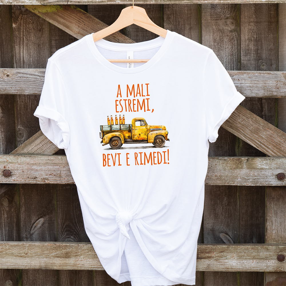 T-shirt A mali estremi... by Il mio negozio: una maglietta bianca con illustrazione di un pickup giallo carico di bottiglie e scritta italiana "A mali estremi, bevi e rimedi!"-perfetta per chi ama magliette divertenti.