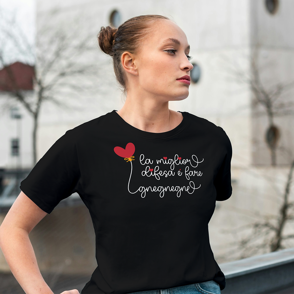 Una "T-shirt Gnegnegne" nera di In Casa di Ale, con scritte bianche e un palloncino rosso a forma di cuore, una delle nostre magliette personalizzate divertenti, posata su una superficie color crema.
