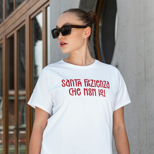 Una donna con gli occhiali da sole indossa la T-shirt Santa de Il mio negozio, una maglietta bianca con un testo rosso in grassetto: "Santa pazienza che non ho!".
