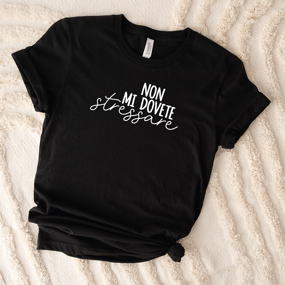 Il mio negozio T-shirt Stressare nera con scritta bianca "NON MI DOVETE stressare" posata su una superficie beige texturizzata.