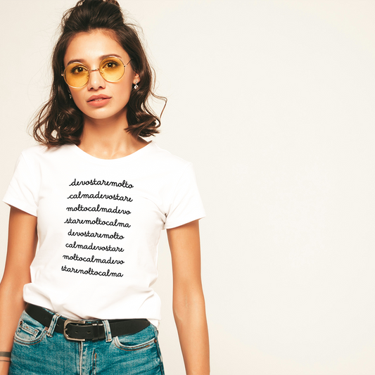 Due magliette Calma o Calmo de Il mio negozio, una bianca e una nera, sono appese a grucce di legno con viti frondose sopra. Queste divertenti magliette italiane sono idee regalo uniche per chi ama lo stile originale.