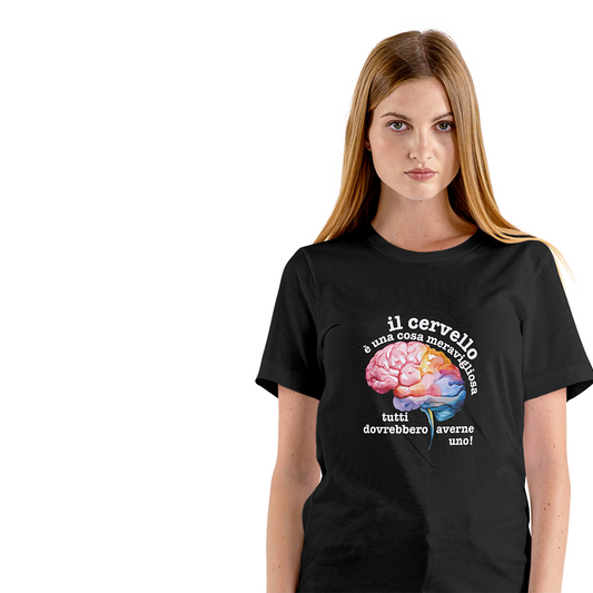 La T-shirt bianca Cervello de Il mio negozio, con un cervello colorato e la frase "Il cervello è una cosa meravigliosa, tutti dovrebbero averne uno!", è appoggiata vicino agli occhiali da sole su una superficie strutturata: una divertente maglietta personalizzata!.