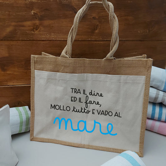 Il Combo Borsa Juta e Telo Fouta MARE di In Casa di Ale è composto da una borsa da spiaggia in juta beige con testo in italiano e tre teli fouta a righe blu, verdi e rosse, ideali per l'estate 2025 al mare.
