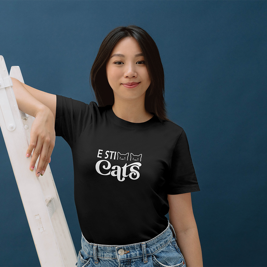 La T-shirt E sticats de Il mio negozio è caratterizzata dal testo nero "E STI Cats" con facce di gatto nel design, perfetto per i fan delle magliette personalizzate divertenti! Da abbinare a sneakers rosa e a un cerchietto nero scintillante con orecchie da Minnie Mouse.