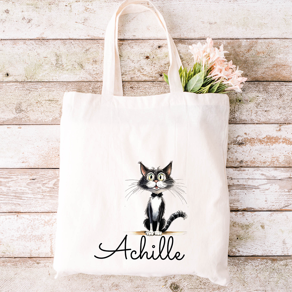 La tote bag bianca con un gatto nero di nome Achille che tiene in mano dei fiori rosa si abbina perfettamente allo Specchietto Tondo di In Casa di Ale per un set regalo unico e personalizzato.