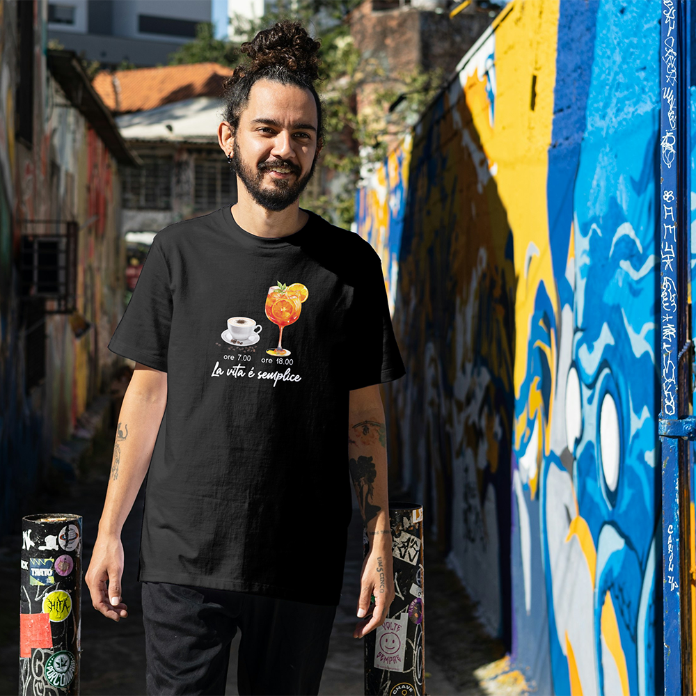 La T-shirt La vita è semplice di Il mio negozio ha illustrazioni di una tazza di caffè (ore 7.00) e un cocktail arancione (ore 18.00), con la frase "La vita è semplice". Ideale per chi ama magliette divertenti e personalizzate.