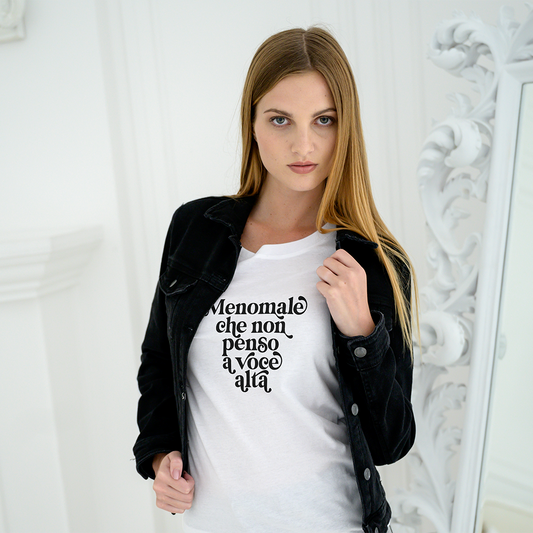 La T-shirt Menomale di Il mio negozio riporta la scritta "Menomale che non penso a voce alta" in bianco su nero, abbinata a shorts in denim, sneakers, cappello di paglia e occhiali da sole per gli appassionati di magliette personalizzate divertenti.