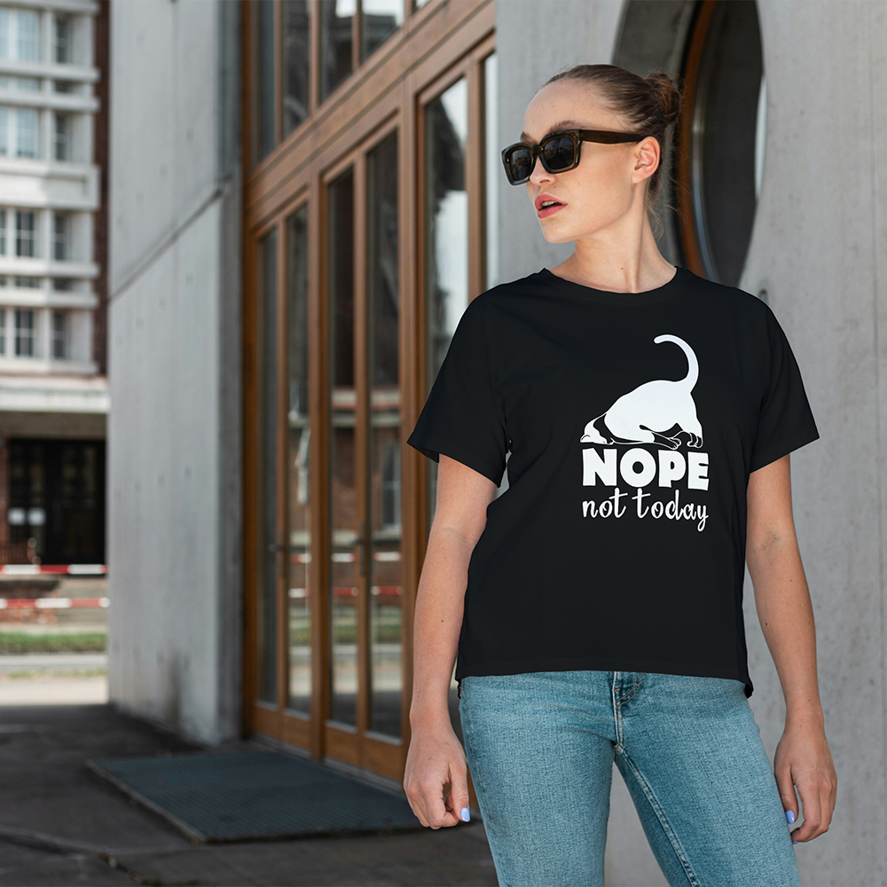 Una donna con occhiali da sole e una maglietta nera de Il mio negozio "Nope Hope Today" si trova all'esterno di un edificio moderno, mostrando come le magliette personalizzate possano aggiungere uno stile unico a qualsiasi abbigliamento.
