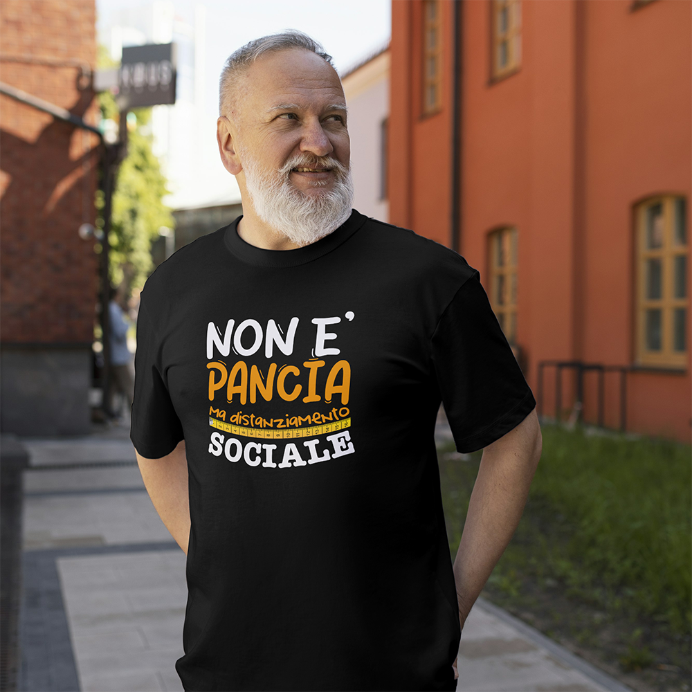 Un uomo sorridente con la barba grigia indossa la T-shirt Pancia de Il mio negozio, con la frase "Non è pancia ma distanziamento sociale": un'idea perfetta per un regalo originale.