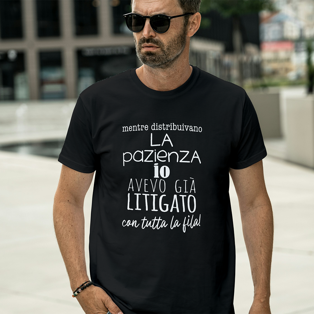 Uomo con occhiali da sole e una "T-shirt Pazienza" nera de Il mio negozio, con una frase umoristica italiana stampata sul davanti.
