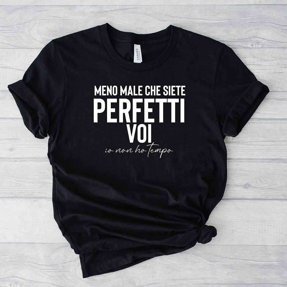 T-shirt Perfetti voi by Il mio negozio: t-shirt nera con testo in italiano "Meno male che siete perfetti voi io non ho tempo" su superficie in legno chiaro, perfetta come maglietta personalizzata o regalo unico.