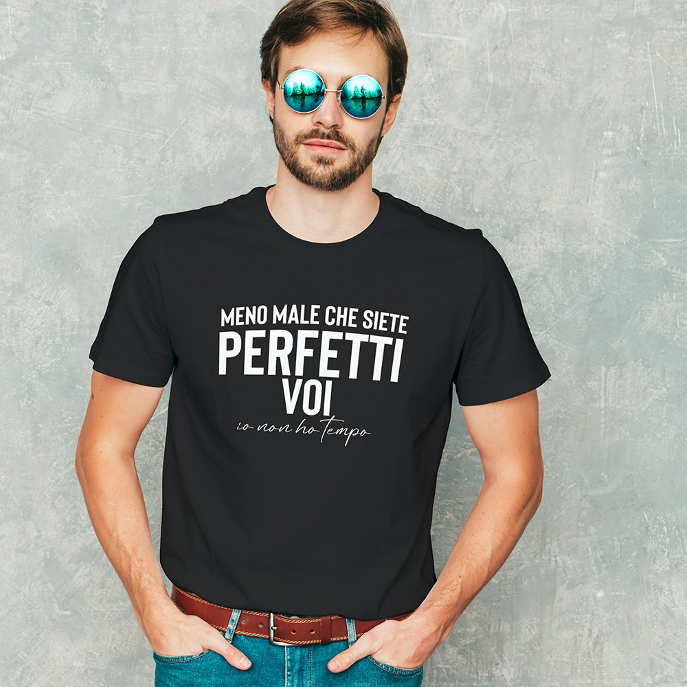 Uomo che indossa la "T-shirt Perfetti voi" de Il mio negozio, con testo italiano, colore nero e occhiali da sole, in posa contro un muro grigio.