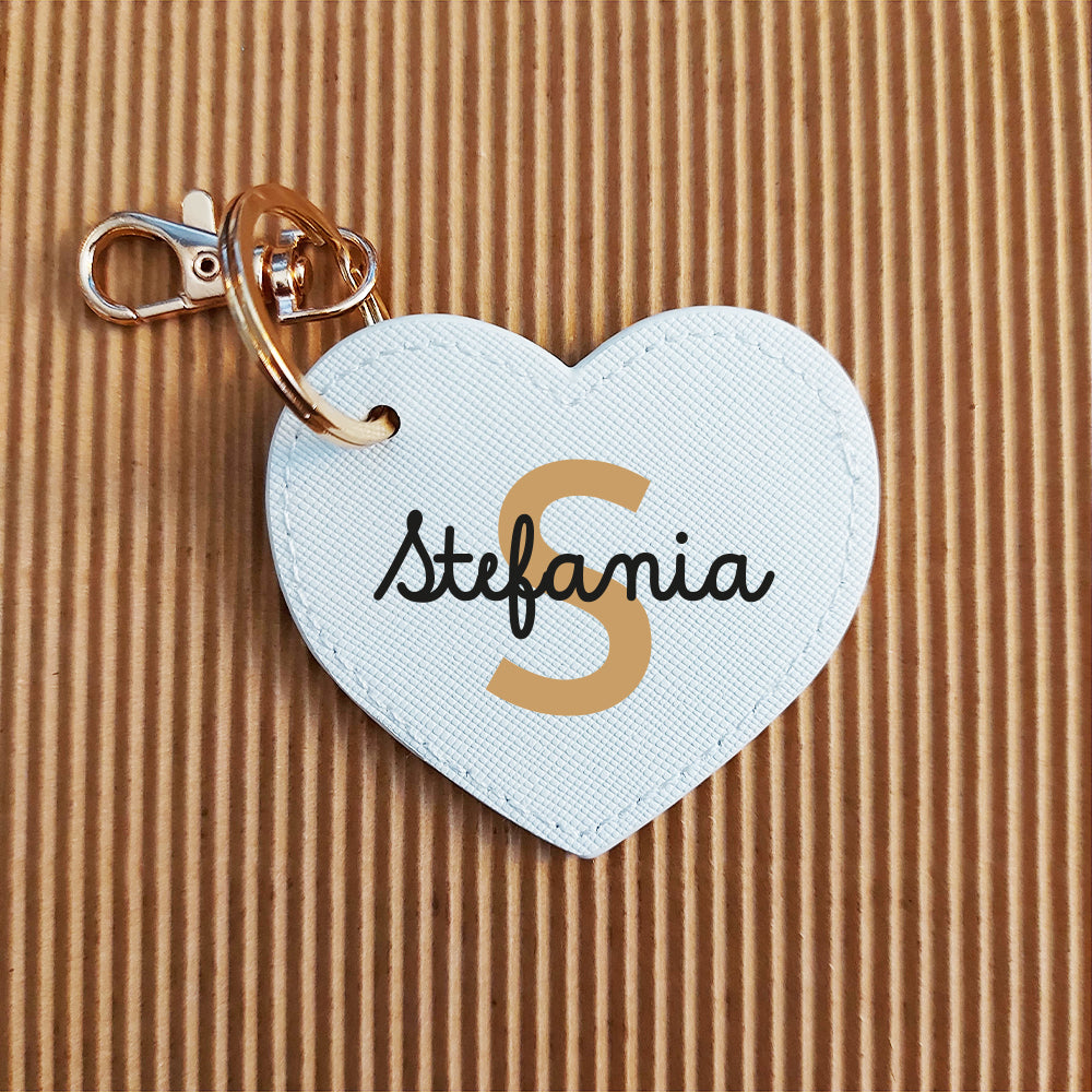 Il Portachiavi Cuore di In Casa di Ale è un portachiavi a cuore in pelle PU bianca con anello dorato, con la scritta "Stefania" e una grande "S" dorata: un accessorio personalizzabile per le vostre chiavi o la vostra borsa.