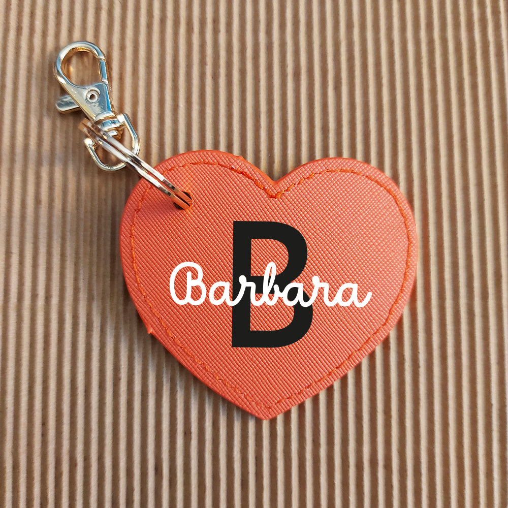 Portachiavi Cuore In Casa di Ale in pelle PU arancione con lettera B e nome Barbara, personalizzabile, posato su tessuto marrone.