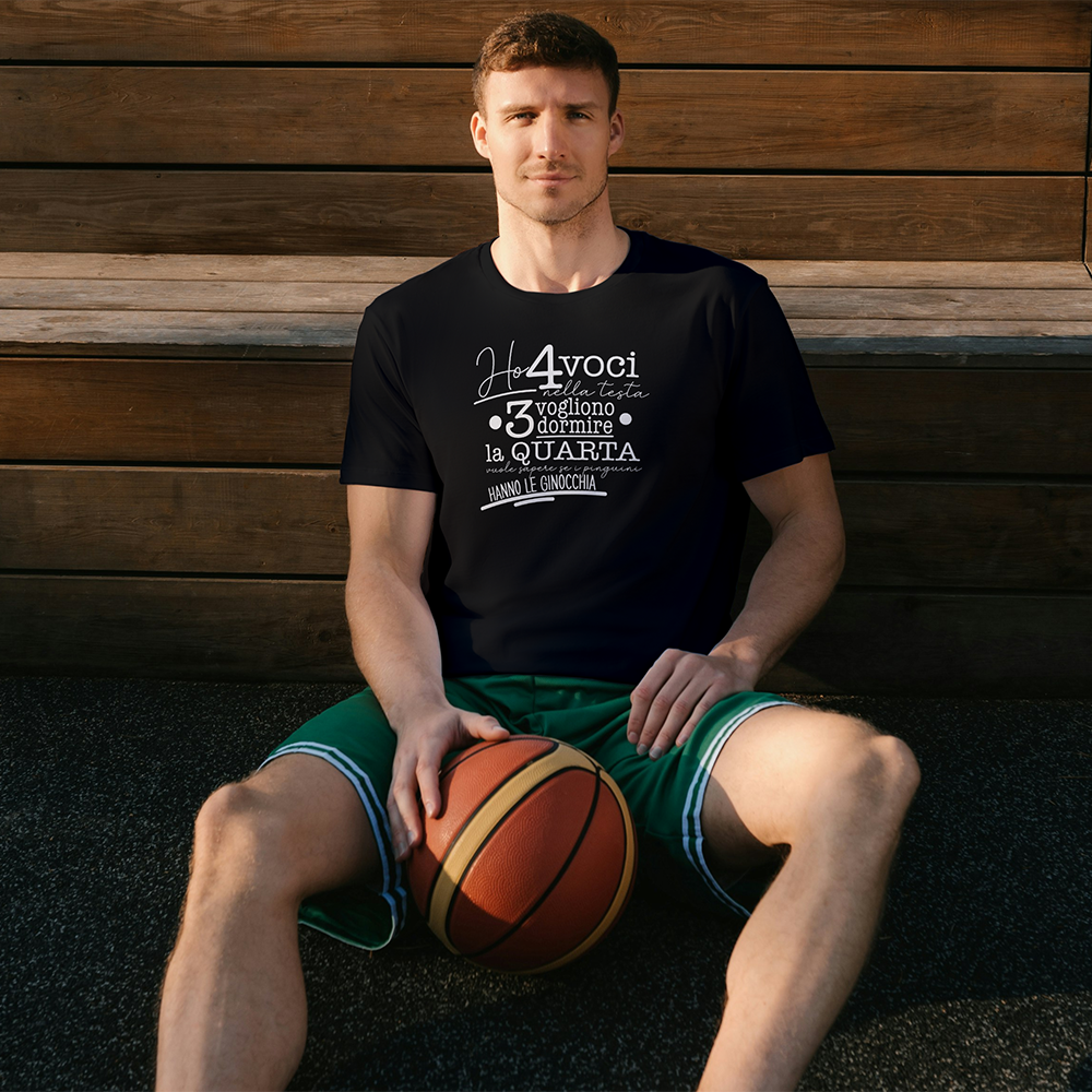 La T-shirt 4 voci de Il mio negozio è appesa a una staccionata di legno. Questa maglietta bianca personalizzata riporta in nero il testo italiano: Ho 4 voci nella testa. 3 vogliono dormire, la quarta vuole sapere se i pinguini hanno le ginocchia.