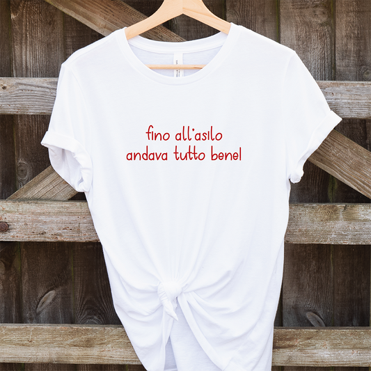 La T-shirt Asilo di Il mio negozio, bianca con scritta rossa "fino all'asilo andava tutto bene!", è perfetta per t-shirt personalizzate o come idea regalo originale.