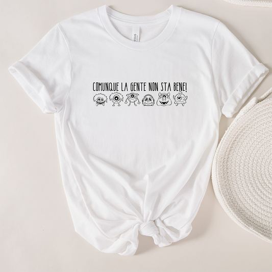 La T-shirt Gente de Il mio negozio riporta la scritta "Comunque la gente non sta bene!" sopra cinque stravaganti mostri dei cartoni animati. Questa divertente t-shirt personalizzata è un ottimo regalo ed è caratterizzata da maniche arrotolate e orlo annodato per un look di tendenza.