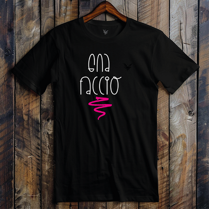 La T-shirt nera Gna faccio di Il mio negozio è appesa a una parete di legno, con la scritta "GNA FACCIO" in bianco con un ghirigoro rosa e un piccolo logo nero sul petto a sinistra, ideale per idee regalo o magliette personalizzate divertenti.