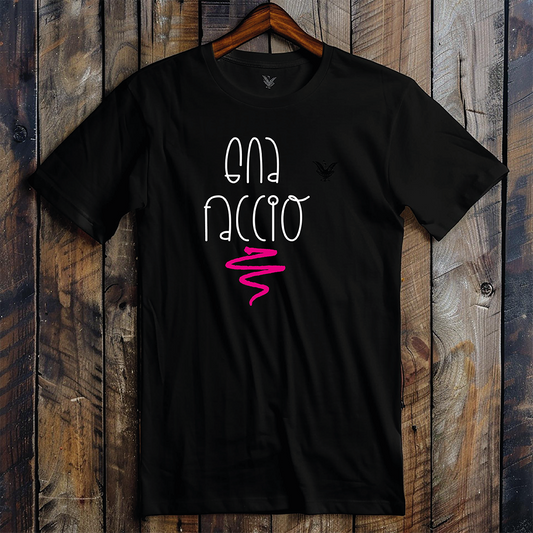 La T-shirt nera Gna faccio di Il mio negozio è appesa a una parete di legno, con la scritta "GNA FACCIO" in bianco con un ghirigoro rosa e un piccolo logo nero sul petto a sinistra, ideale per idee regalo o magliette personalizzate divertenti.