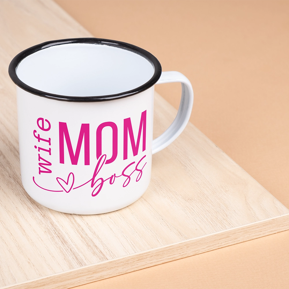Mug in alluminio dedicata alla mamma con scritta Wife Mom Boss in rosa, appoggiata su vassoio in legno chiaro.