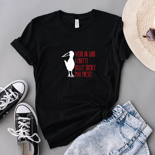 La T-shirt Sberle di Il mio negozio presenta una grafica con cicogna bianca e testo italiano su sfondo nero, abbinata con stile a pantaloncini di jeans, cappello e sneakers nere.