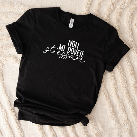 Il mio negozio T-shirt Stressare nera con scritta bianca "NON MI DOVETE stressare" posata su una superficie beige texturizzata.