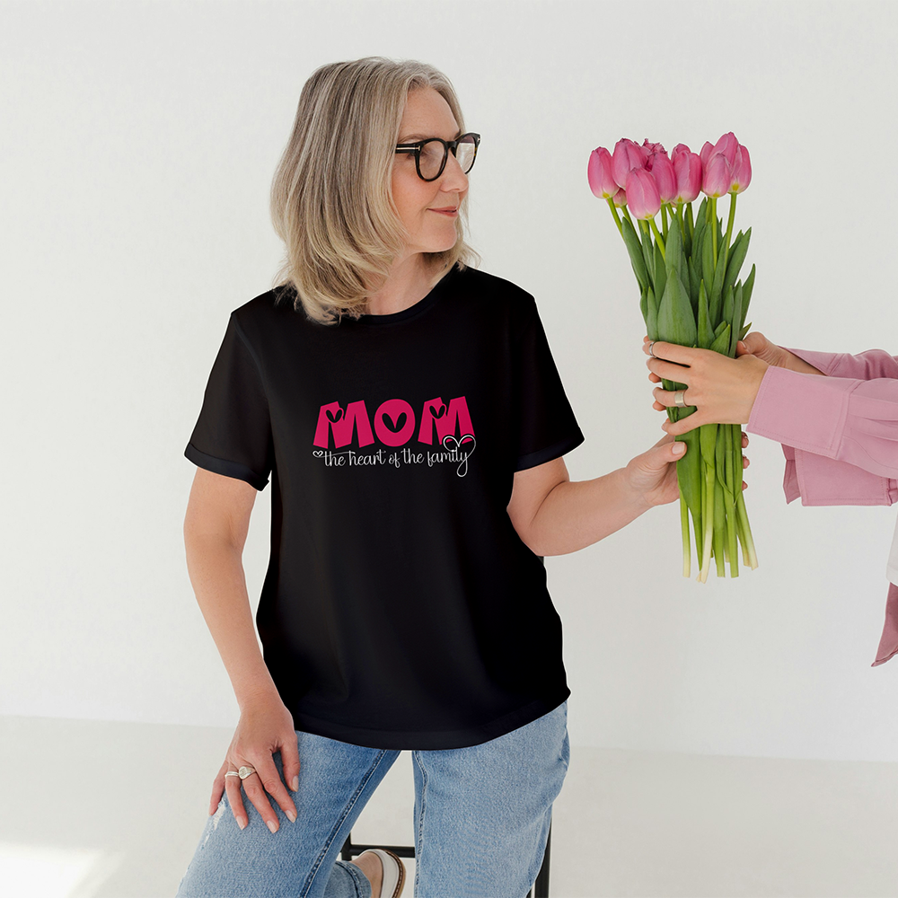 Donna con t-shirt nera Mom The Heart of the Family mentre riceve un mazzo di tulipani, idea regalo per la mamma.