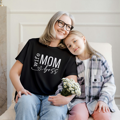 Mamma con t-shirt nera Wife Mom Boss seduta accanto a una bambina, in dolce foto lifestyle dedicata alla Festa della Mamma.