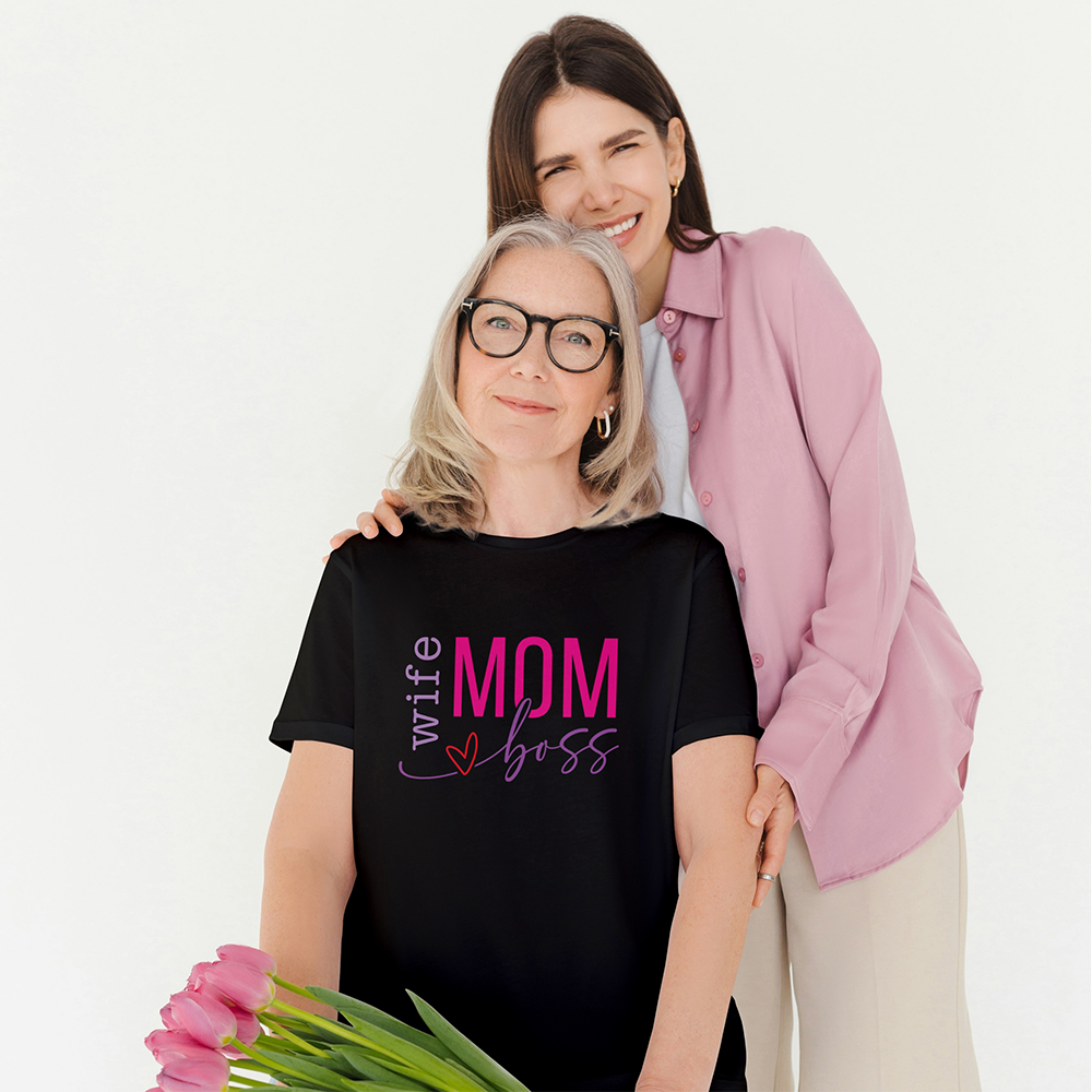 Mamma con t-shirt nera Wife Mom Boss insieme alla figlia, con tulipani rosa in una foto dal tono affettuoso.