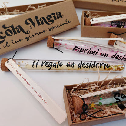 Dettaglio ampollina dei desideri con scritta Ti regalo un desiderio, tag con frase e scatolina kraft Piccola Magia