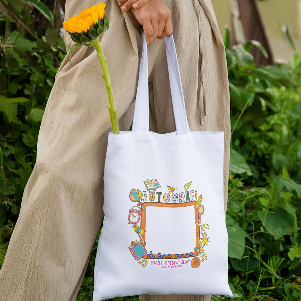 Tote bag Autografi di Fine Anno personalizzata per maestra o maestro, appesa in ambientazione naturale