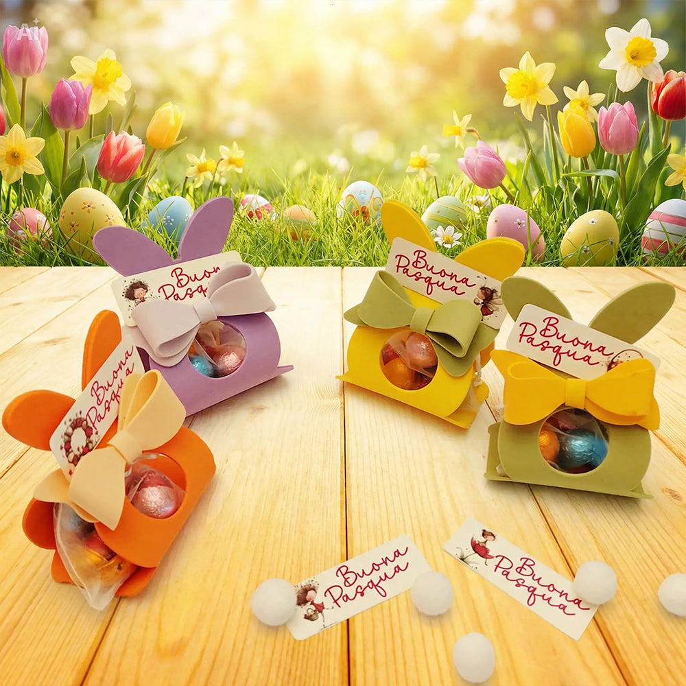 Coniglietti di Pasqua colorati con ovetti assortiti in ambientazione primaverile su tavolo in legno