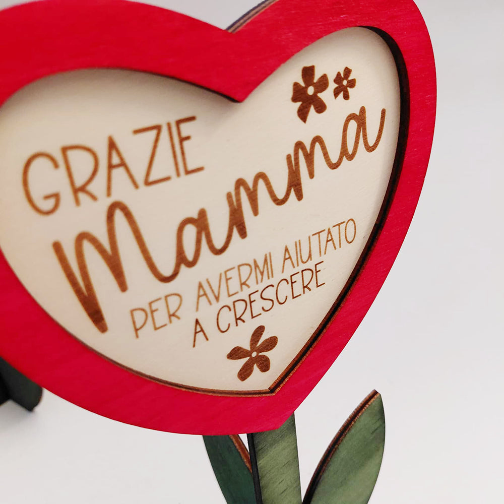Dettaglio del cuore in legno con dedica Grazie Mamma per avermi aiutato a crescere