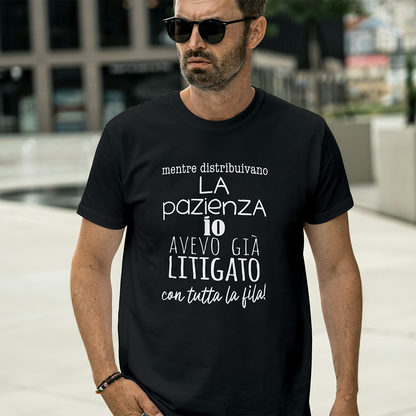 Uomo con occhiali da sole e una "T-shirt Pazienza" nera de Il mio negozio, con una frase umoristica italiana stampata sul davanti.