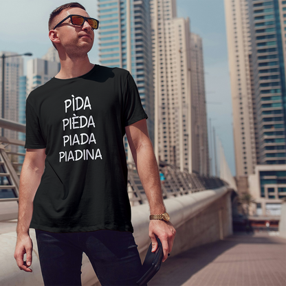 Uomo che indossa la T-shirt Piadina de Il mio negozio con testo PiDA PiEDA PiADA PiADINA, in piedi in una città: un'idea regalo originale e un ottimo esempio delle nostre T-shirt personalizzate.
