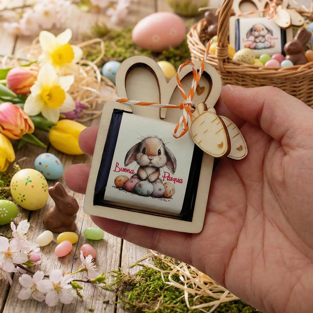 Porta cioccolatino di Pasqua in legno tenuto in mano con ambientazione pasquale, ovetti colorati e fiori