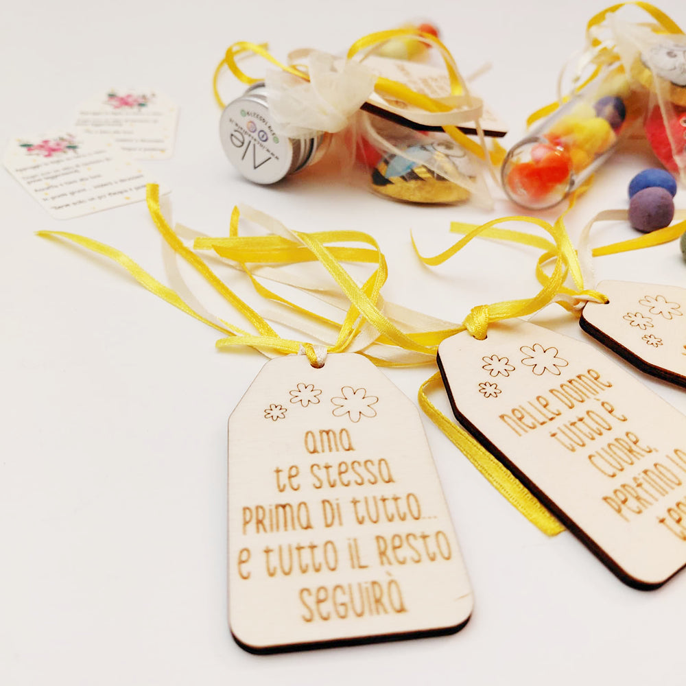 Provetta Festa della Donna con tag in legno inciso e confezione regalo, dettaglio su sfondo chiaro