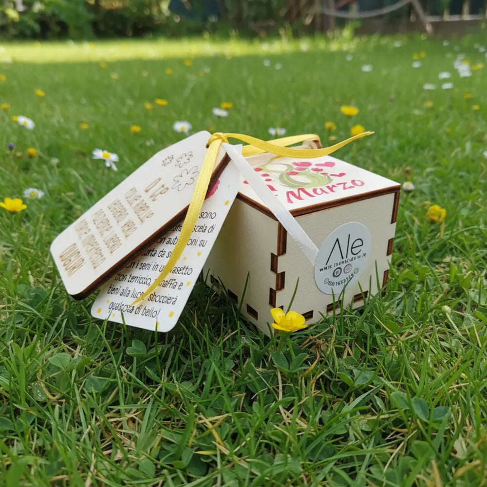 Scatolina in legno 5x5 per Festa della Donna con coperchio decorato, tag con dedica e nastri gialli, foto su prato