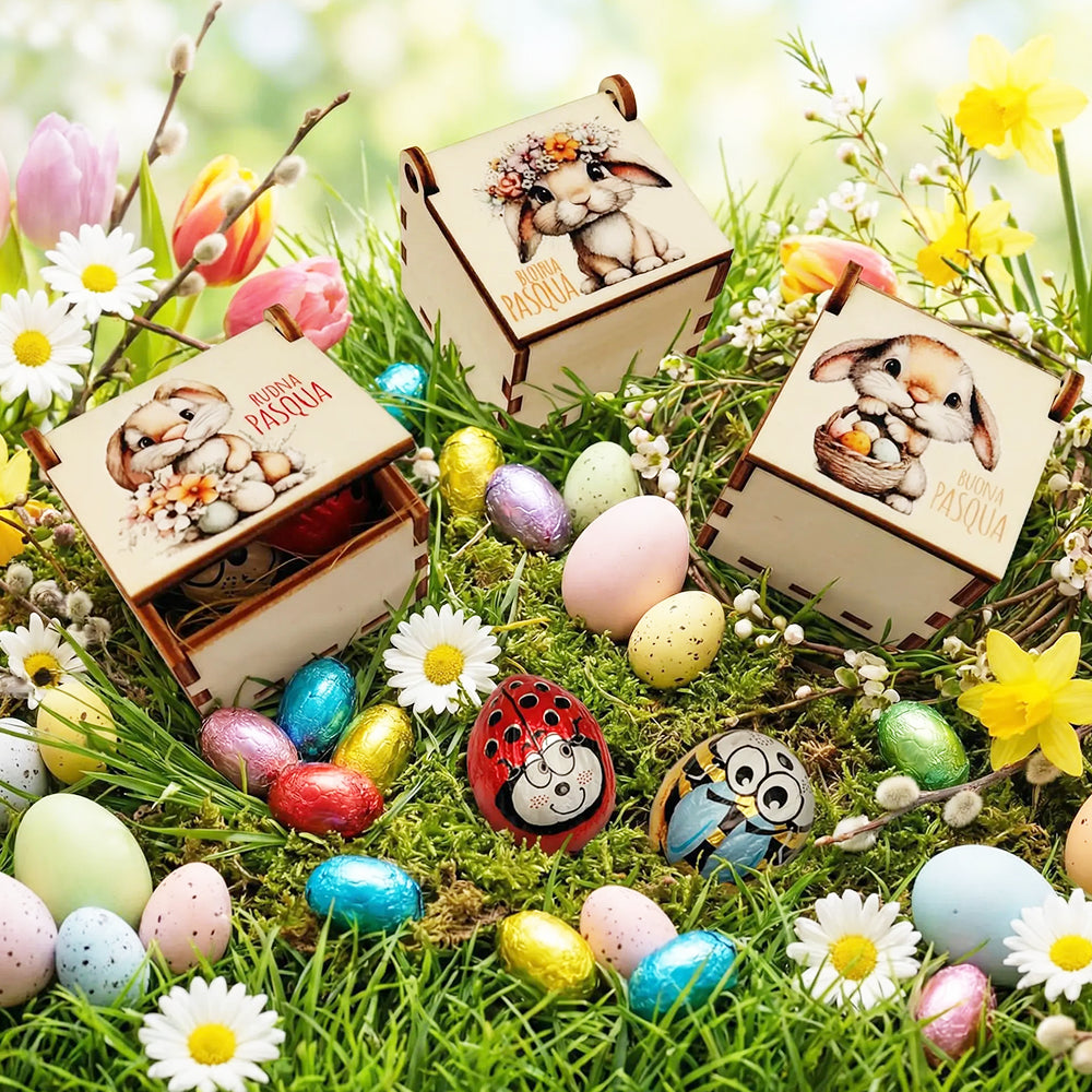 Scatoline pasquali in legno con immagini di coniglietti ambientate su prato con ovetti colorati e fiori primaverili