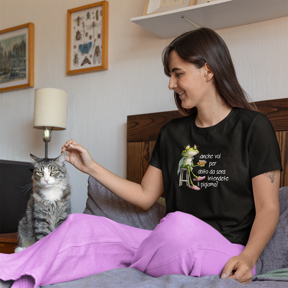 Donna con t-shirt nera con frase anche voi per abito da sera intendete il pigiama seduta sul letto con gatto