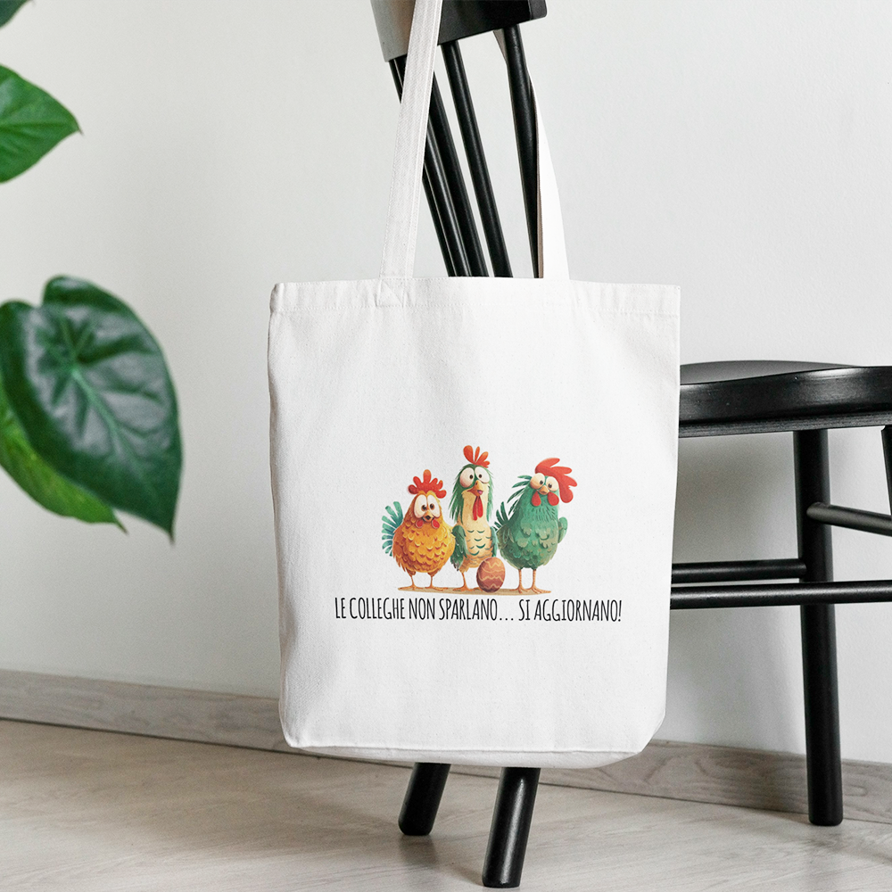 Tote bag con illustrazione di galline e frase sulle colleghe, shopper in cotone bianca appesa a una sedia