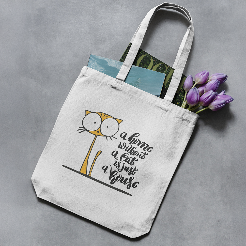 Tote bag con illustrazione di gatto e scritta A home without a cat is just a house, shopper in cotone bianca vista dall’alto