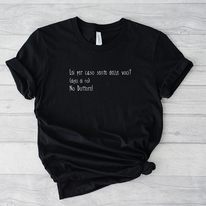 Il mio negozio T-shirt Sento voci nere con la scritta italiana "Lei per caso sente delle voci? (dica di no) No Dottore!" su sfondo in legno chiaro.
